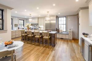 Una cocina con una gran isla con taburetes de bar. en The Royce - Two Luxury Family Homes in Downtown Newport, en Newport 76 fotos más