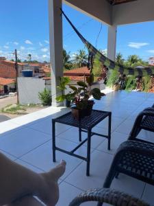 a porch with a hammock and a table and chairs at Pousada Dona Dulce in Barreirinhas