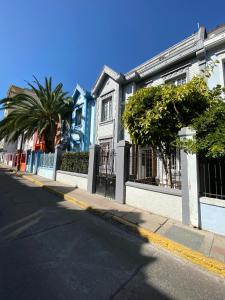 a street with a blue and white building and palm trees at Tremo Bustamante in Santiago