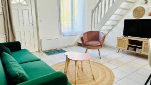 a living room with a green couch and a chair at Chez Mag maison de pêcheur proche plage in Ault