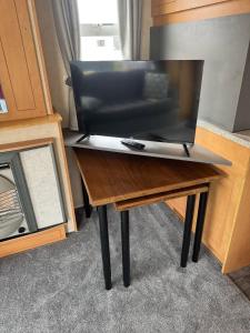 a tv on a wooden table with a television on it at 4 Berth Static Caravan Golden Palm Resort with Decking in Chapel Saint Leonards