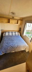 a bed in the middle of a tiny house at 4 Berth Static Caravan Golden Palm Resort with Decking in Chapel Saint Leonards