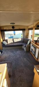 a living room with a couch in an rv at 4 Berth Static Caravan Golden Palm Resort with Decking in Chapel Saint Leonards