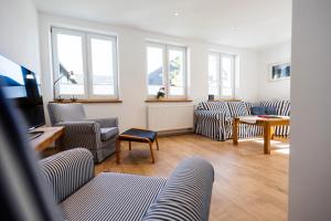 a living room with couches and a tv and windows at Conzen Hof am Hennesee in Meschede