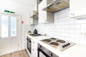 cocina blanca con fogones en Teesside House - Sleeps up to 10, en Redcar