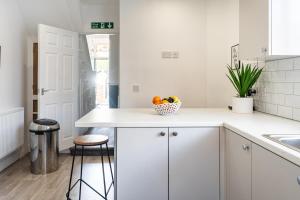 una cocina con armarios blancos y un bol de fruta en Teesside House - Sleeps up to 10, en Redcar 37 fotos más