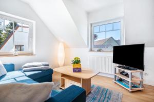 a living room with a blue couch and a tv at Ferienwohnung 2 in Groß Zicker