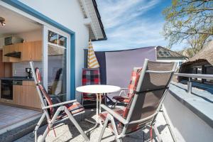 a patio with chairs and a table on a balcony at Ferienwohnung 2 in Groß Zicker