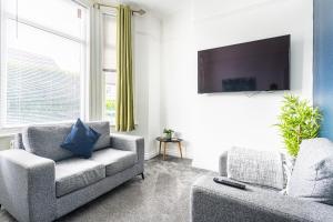 Una sala de estar con un sofá y un televisor. en Teesside House - Sleeps up to 10, en Redcar