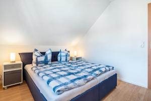 a bedroom with a large blue bed with blue pillows at Ferienwohnung 2 in Groß Zicker