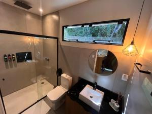 a bathroom with a toilet and a sink and a shower at RASTRO Cabins in Restinga Sêca +17 photos