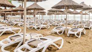 a bunch of chairs and umbrellas on a beach at Bonita Luxury Resort & Spa in Durrës