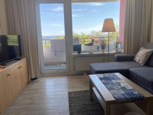 a living room with a couch and a large window at Berolina 316 - Möwennest in Dahme