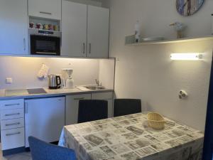 a kitchen with a table with chairs and a counter top at Berolina 316 - Möwennest in Dahme