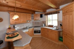 a kitchen with wooden cabinets and a counter top at Appartementhaus Parzer in Pruggern