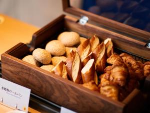 a wooden box filled with different types of bread at Bande Hotel Tenpozan Higashi in Osaka