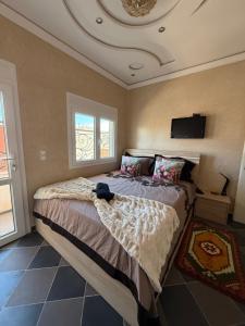 a bedroom with a bed and a tv on the ceiling at Sea View Apartment in Mirleft