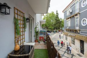 un balcone di un edificio con persone che camminano per strada di FM Herculano - Sea, Sun & Fun a Cascais