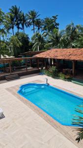 a large blue swimming pool next to a resort at Cores de Boipeba in Ilha de Boipeba