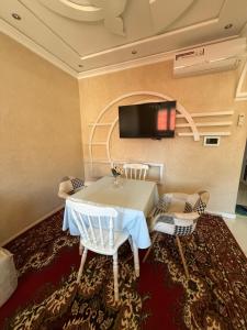 a room with a table and two chairs and a tv at Sea View Apartment in Mirleft
