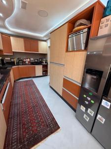 a kitchen with wooden cabinets and a rug on the floor at Sea View Apartment in Mirleft