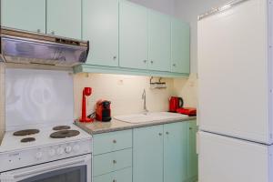a kitchen with white appliances and blue cabinets at Hidden Pine in Pefkohori