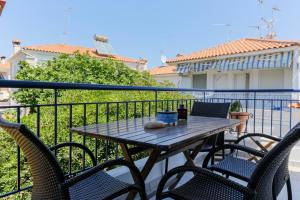 a table and chairs on the balcony of a house at Hidden Pine in Pefkohori