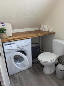 a bathroom with a washing machine and a toilet at Chez Camille in Dives-sur-Mer