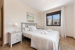two beds in a white bedroom with a window at Golf Hills in Estepona