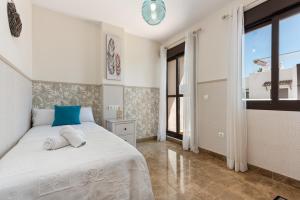 a bedroom with a white bed with a blue pillow at Golf Hills in Estepona +23 photos