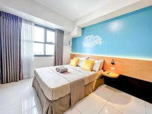 a bedroom with a large bed with a blue wall at Cozy Space at Horizons 101 Cebu City with Pool, Netflix, Wifi in Cebu City