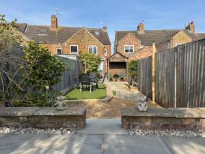 a home with a fence and a backyard with a yard at 57 Southend Road in Hunstanton
