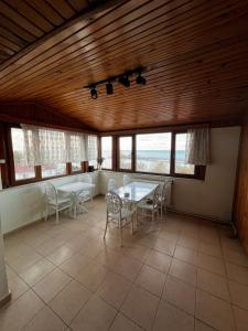 a dining room with a table and chairs and windows at Deniz pansiyon in Akçakoca