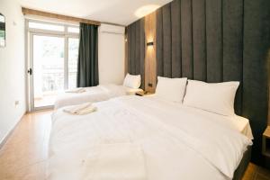 Postel nebo postele na pokoji v ubytování Hotel Dajti