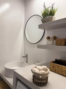 a bathroom with a sink and a toilet and a mirror at Vista del Porto Apartment in Gavrio +10 photos