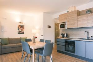een keuken en woonkamer met een houten tafel en stoelen bij Costa Blu - Pool and terrace overlooking the lake in Riva di Solto