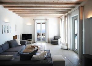 a living room with a couch and a table at Exquisite Mykonos Villa Villa Ammos 4 Bedroom Private Pool Sea View Houlakia in Mýkonos City