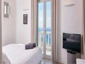 une chambre avec un lit et une télévision à écran plat dans l'établissement Exquisite Mykonos Villa Villa Exclusive 3 Bedroom Private Pool, à Mykonos 6 autres photos