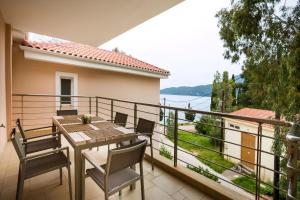 balkon ze stołem i krzesłami oraz widokiem w obiekcie Deluxe Kefalonia Apartment Apartment Neroli 2 Bedroom Pool Karavomilos w mieście Karavomylos