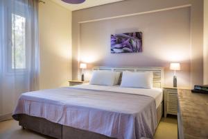 sypialnia z dużym białym łóżkiem z 2 poduszkami w obiekcie Deluxe Kefalonia Apartment Apartment Neroli 2 Bedroom Pool Karavomilos w mieście Karavomylos