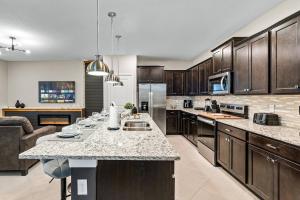 a kitchen with wooden cabinets and a counter top at Brand New Charming Home 9 Miles To Disney in Orlando