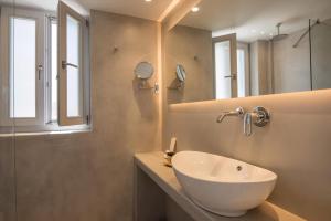 a bathroom with a white sink and a mirror at Gorgeous Paros Villa 3 Bedrooms Villa Harmony Private Outdoor Jacuzzi & Garden Views Naousa in Livadia