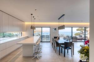 a kitchen and dining room with a table and chairs at Super Luxury Skiathos Villa Seven Stunning Bedroom Suites Villa Levanta Achliades in Achladies