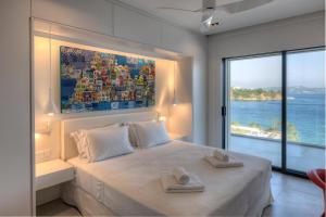 a bedroom with a large bed with two towels on it at Super Luxury Skiathos Villa Seven Stunning Bedroom Suites Villa Levanta Achliades in Achladies +32 photos
