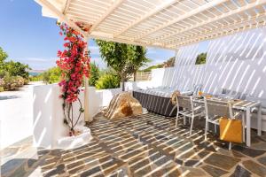 une pergola avec une table et des chaises sur une terrasse dans l'établissement Luxury Paros Villa 1 Bedroom The Cobble Suite Private Jacuzzi & Private Terrace Naousa, à Kampos Paros