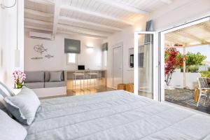 une chambre avec un grand lit et un salon dans l'établissement Luxury Paros Villa 1 Bedroom The Cobble Suite Private Jacuzzi & Private Terrace Naousa, à Kampos Paros