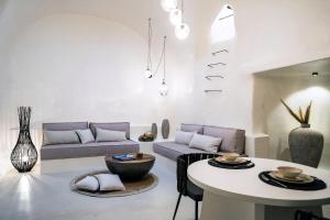 a living room with a couch and a table at Wonderful Santorini Villa 1 Bedroom Villa Gonia Astonishing Views & Outdoor Jacuzzi Exo Gonia in Éxo Goniá