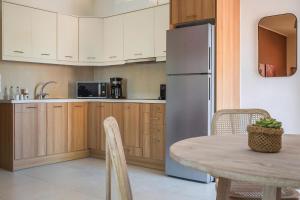 a kitchen with a table and a refrigerator at Deluxe Kefalonia Apartment Apartment Perla 1 Bedroom Pool Sea View Karavomilos in Karavomylos