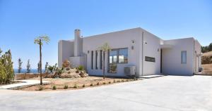Biały dom z palmami przed nim w obiekcie Elite Crete Villa Villa Kallia 3 Bedroom Sea View Private Pool Aghia Pelagia w mieście Agia Pelagia