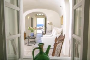 salon z białą kanapą i stołem w obiekcie Elegant Santorini Villas Villas Aloia Private Hot Tub Air Conditioning 1 Bedrooms Oia w mieście Oia